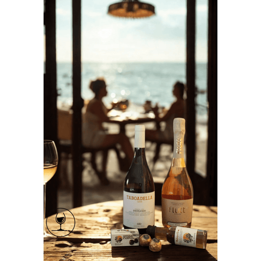 Romantic dinner setup with wine bottles and gourmet treats, featuring a sunset view by the sea.